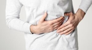 Cirrhosis of liver. Man holding hand in area liver